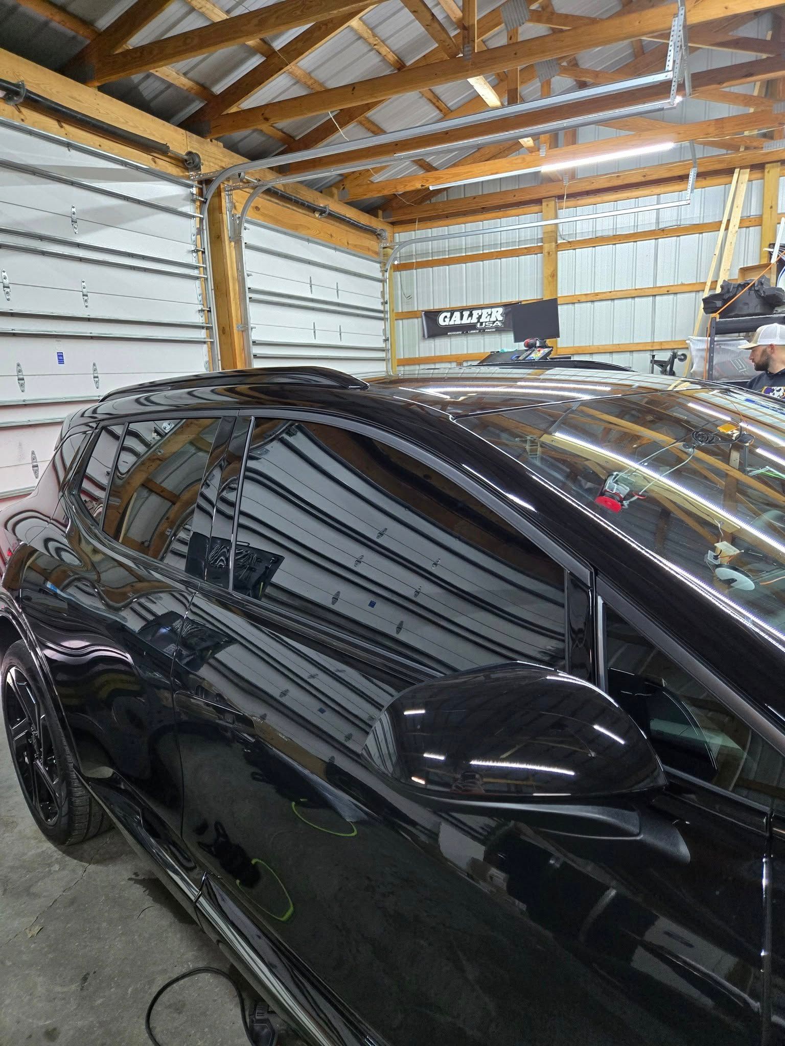 A black car is parked in a garage.