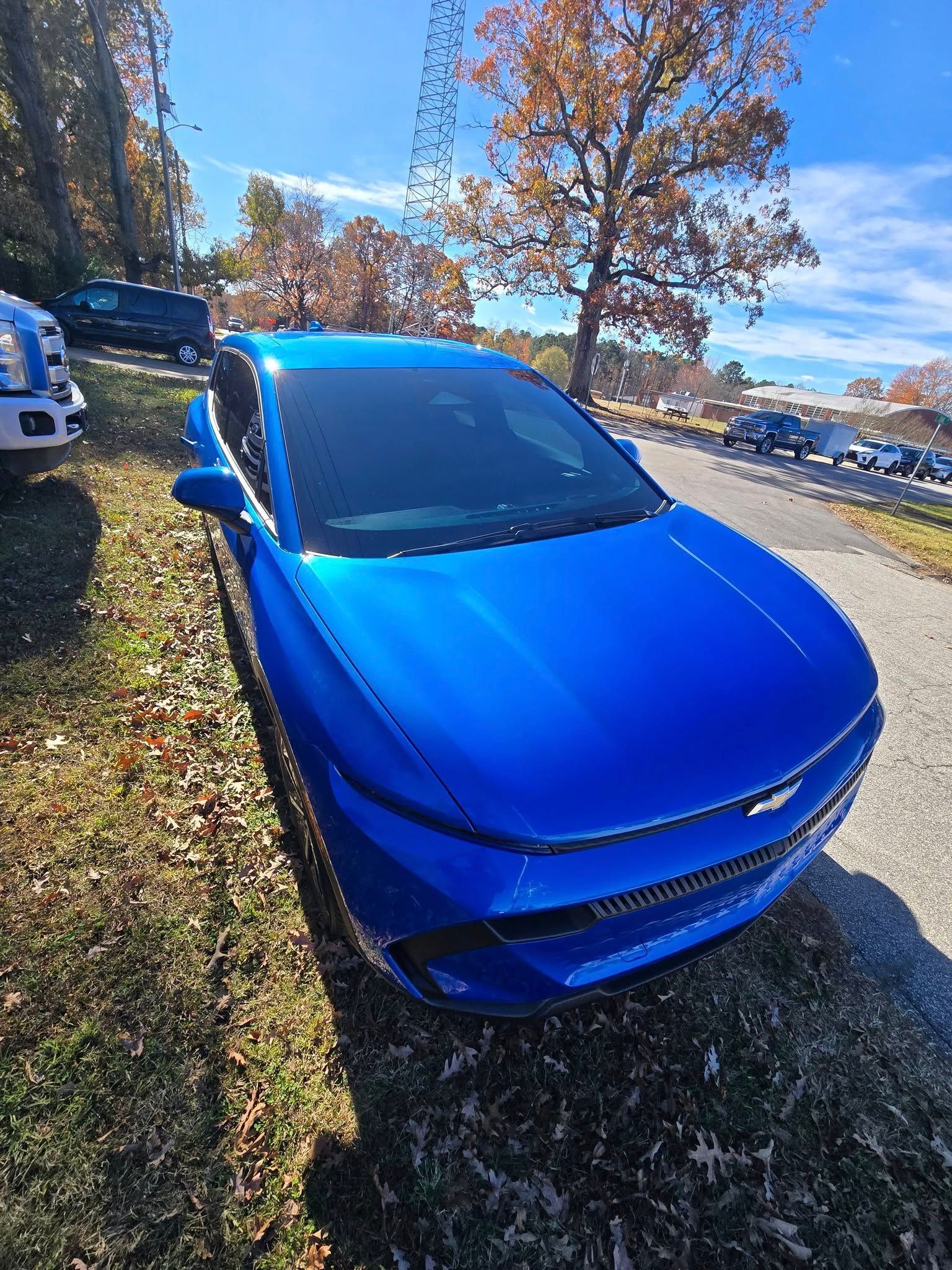 A blue car is parked on the side of the road.