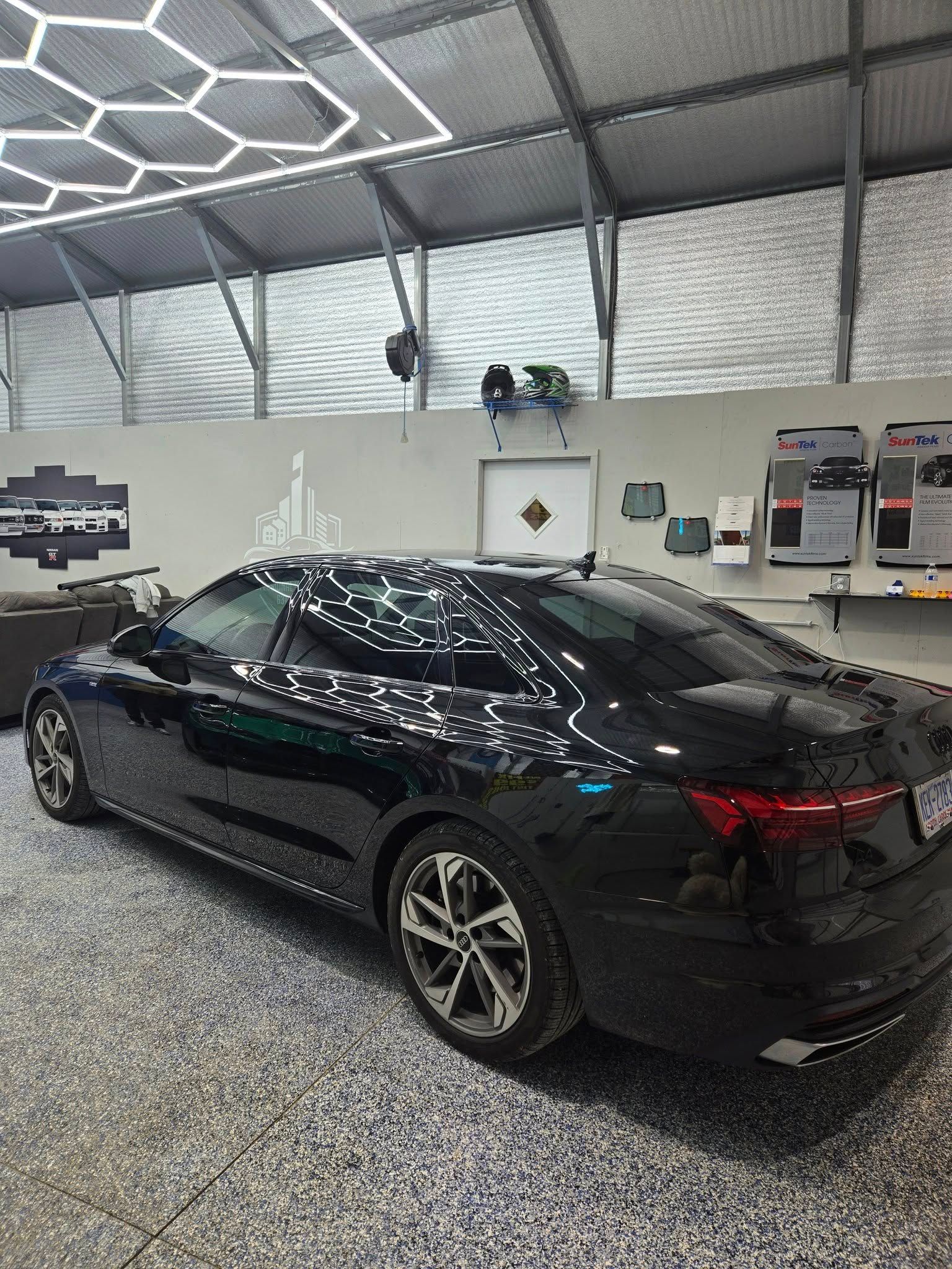 A black car is parked in a garage.