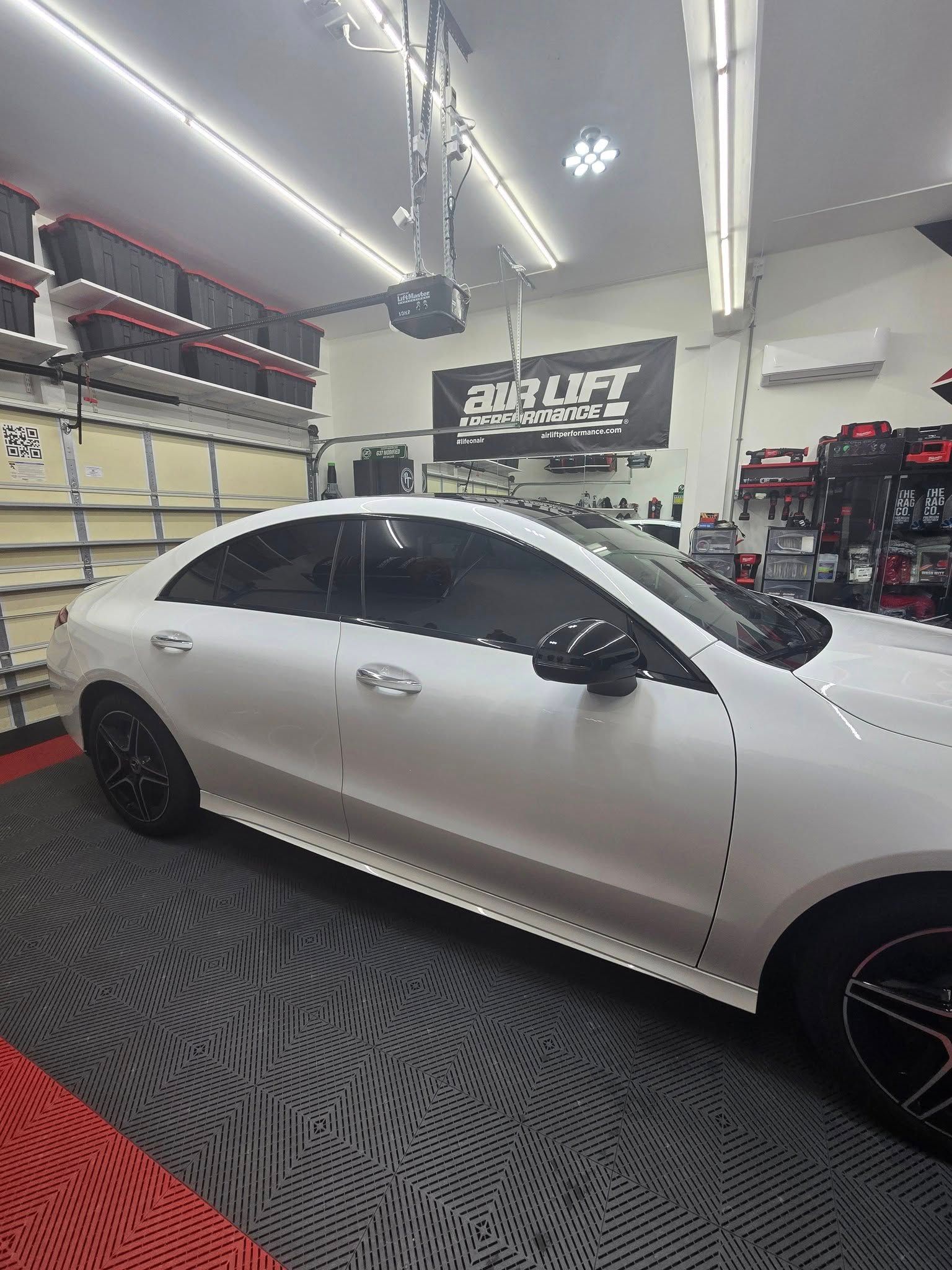 A white car is parked in a garage.