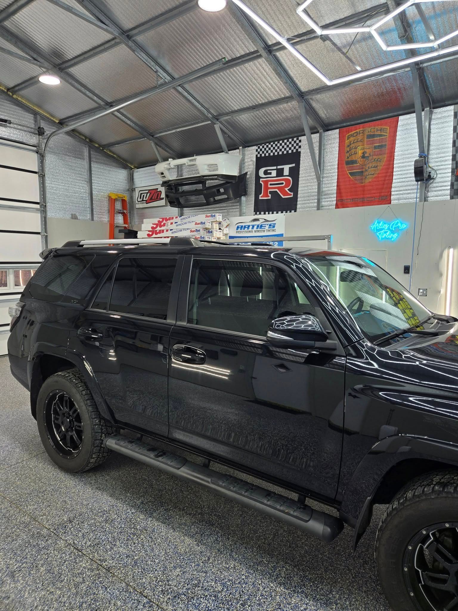 A black suv is parked in a garage.