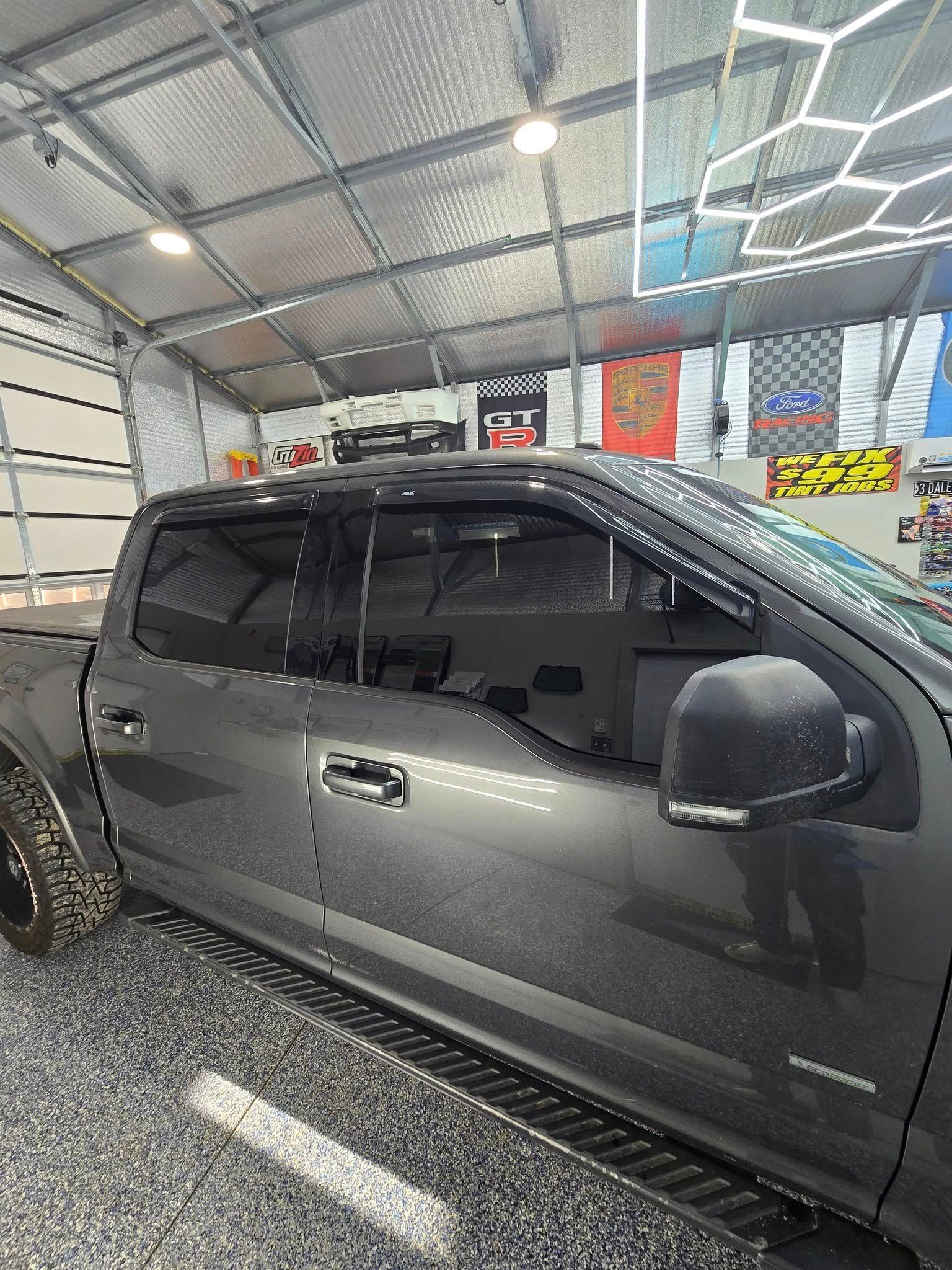 A gray truck is parked in a garage.