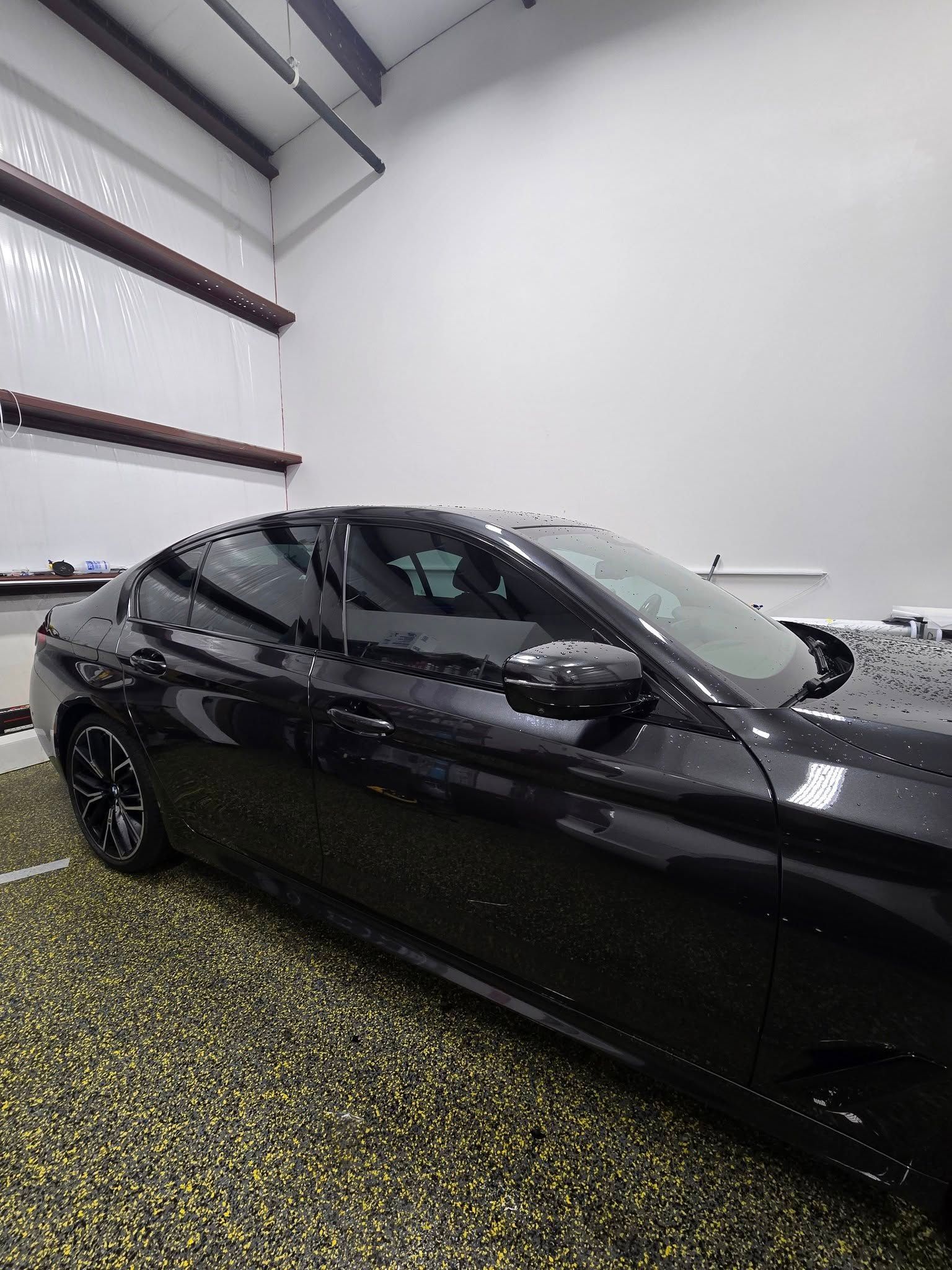 A black car is parked in a garage.