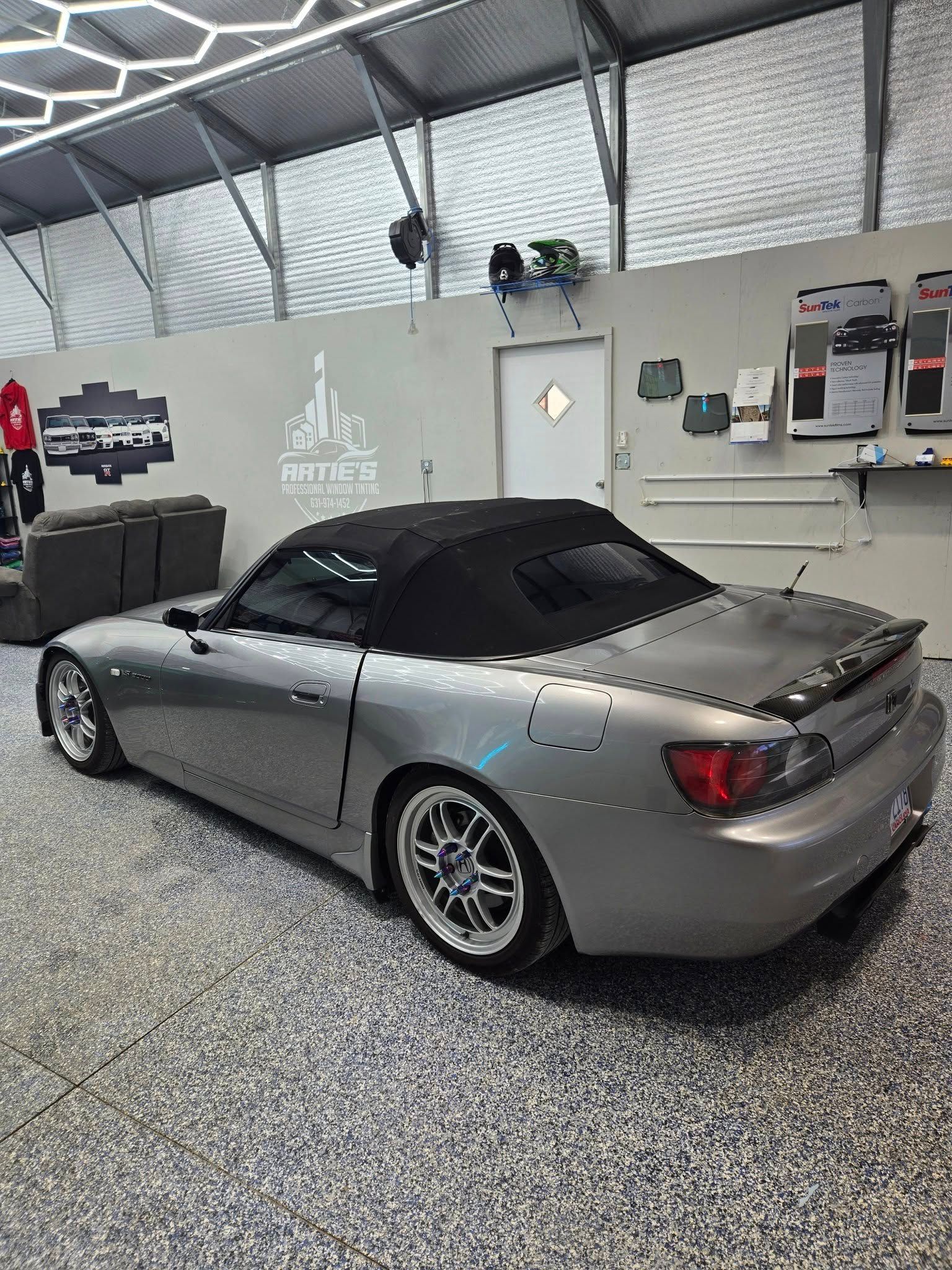 A silver sports car is parked in a garage.