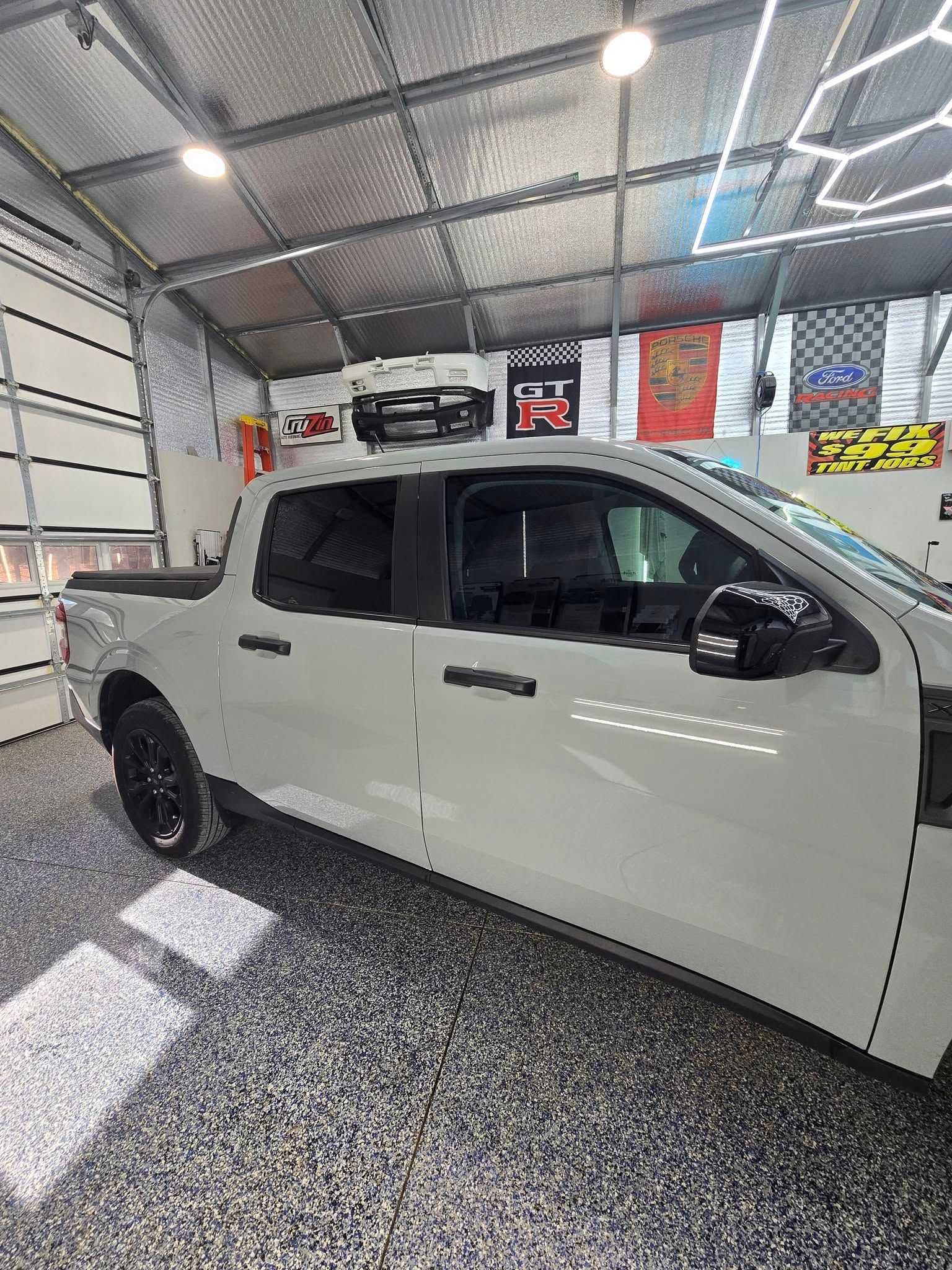A white truck is parked in a garage.