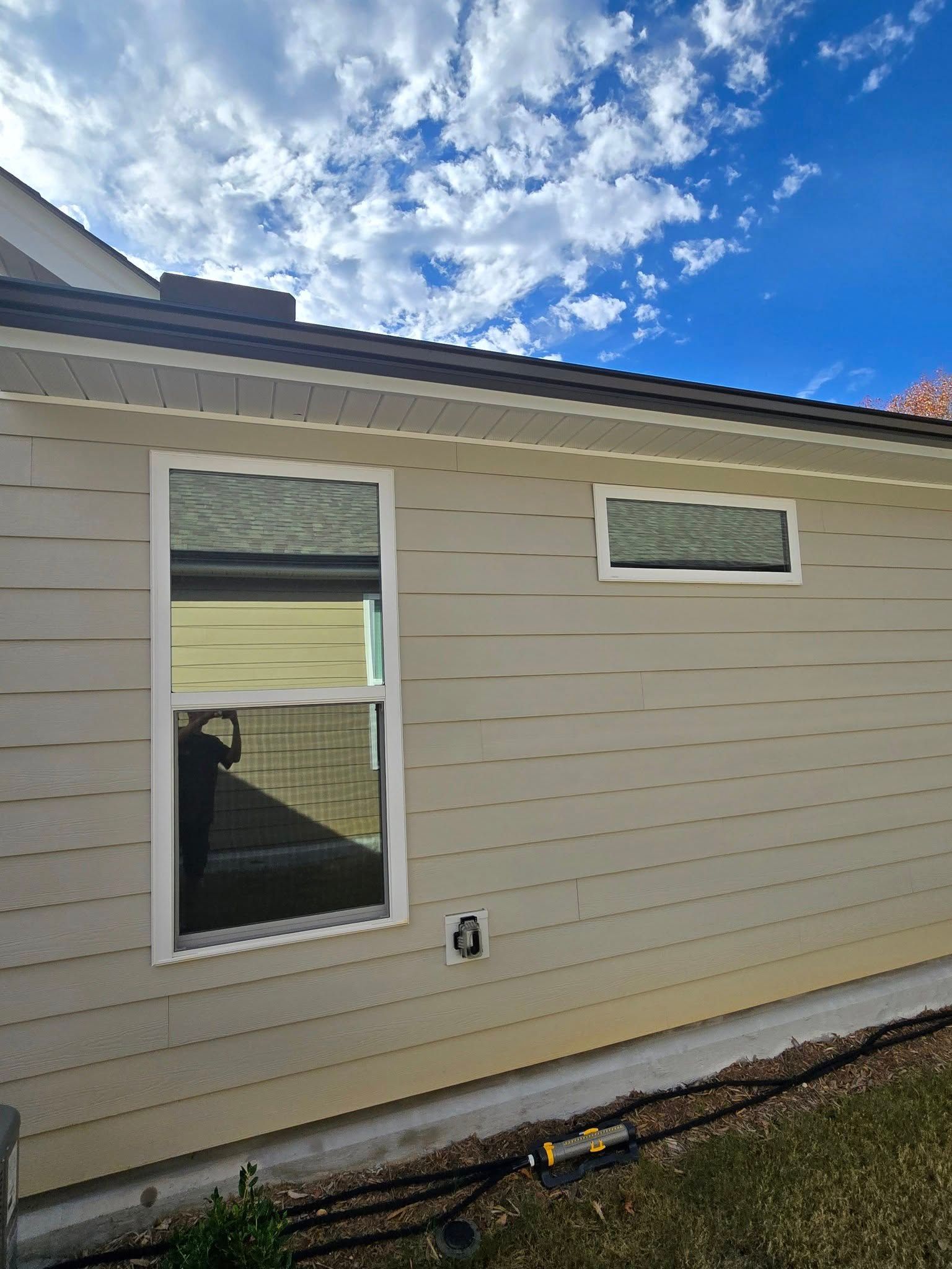 A house with a lot of windows and a blue sky in the background.