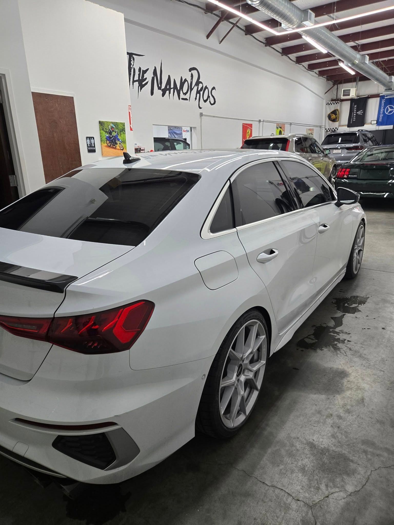 A white car is parked in a garage.