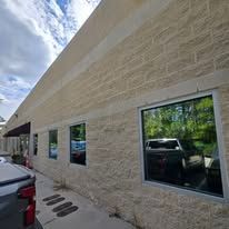A brick building with a lot of windows and a truck parked in front of it.