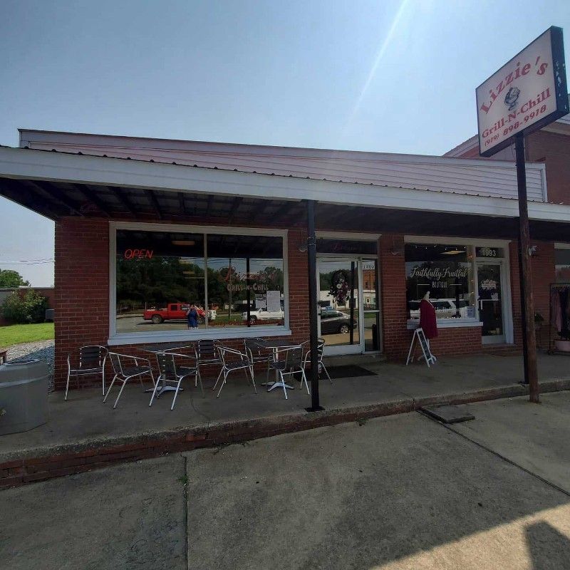 A brick building with tables and chairs in front of it