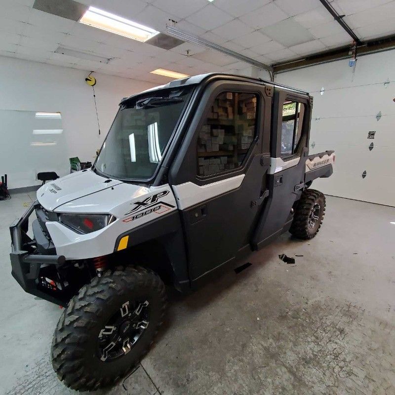 A black and white vehicle is parked in a garage.
