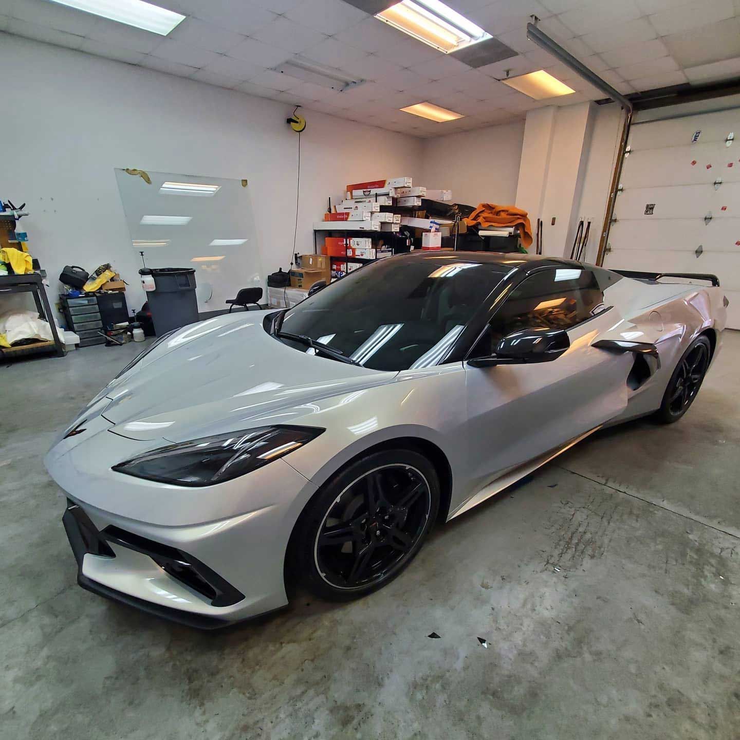 A silver sports car is parked in a garage.