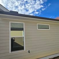A house with a lot of windows and a blue sky in the background.