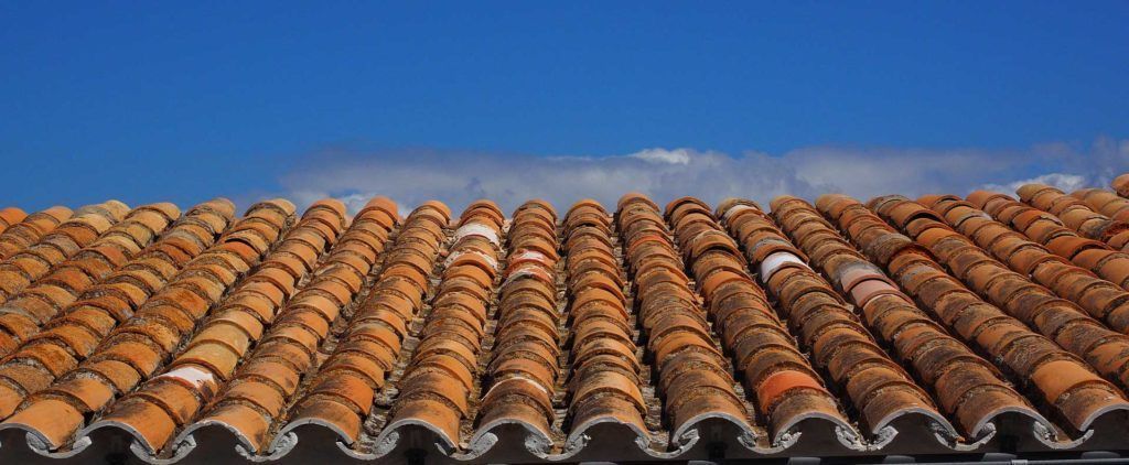 Clay tile roof against a bright blue sky.