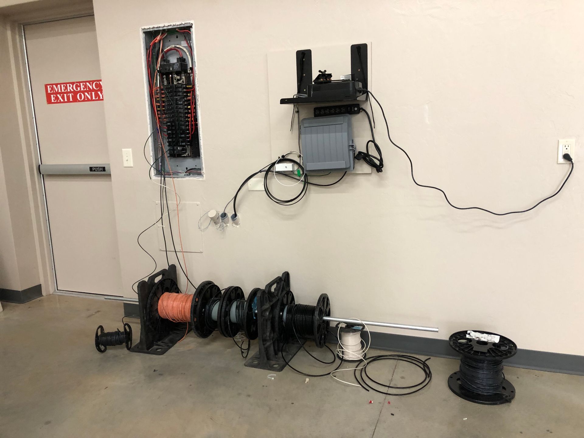 a bunch of wires are hanging on a wall in a room