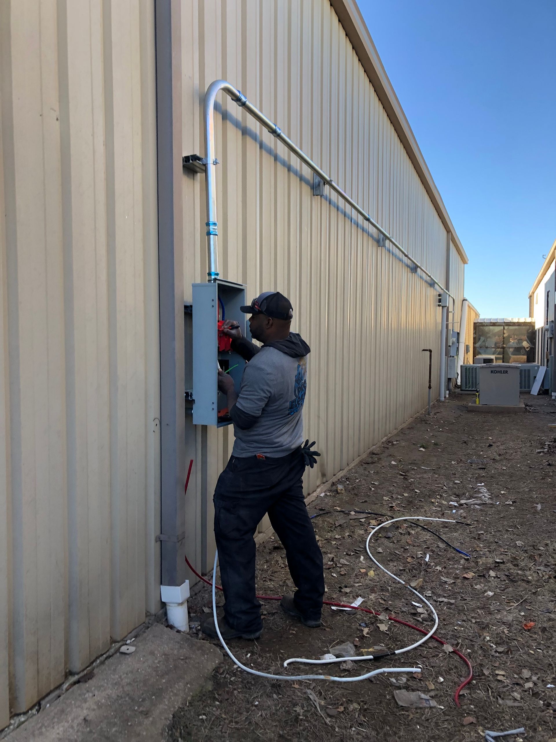a man is working on an electrical box on the side of a building