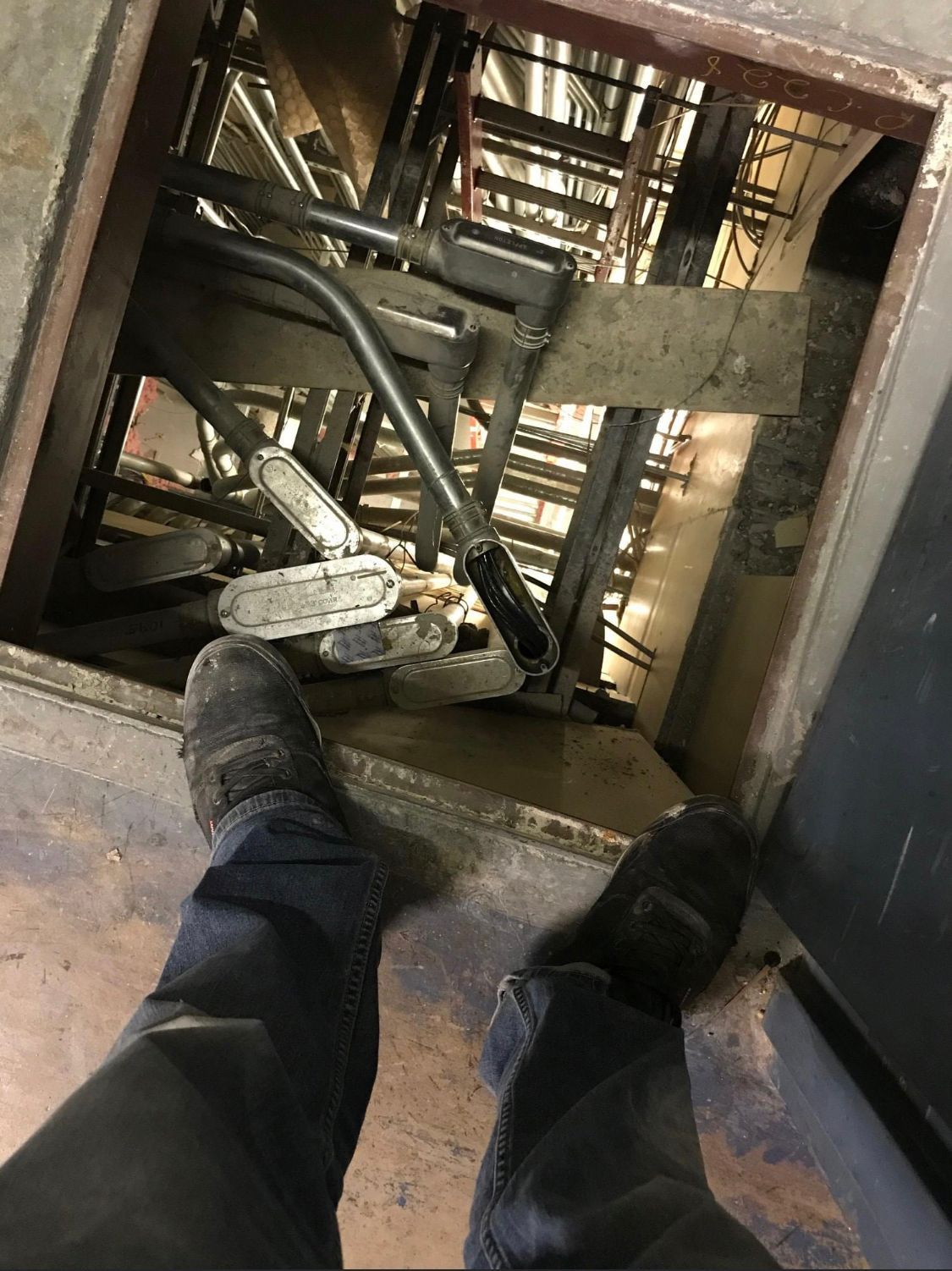a person is standing in an elevator looking down at the stairs