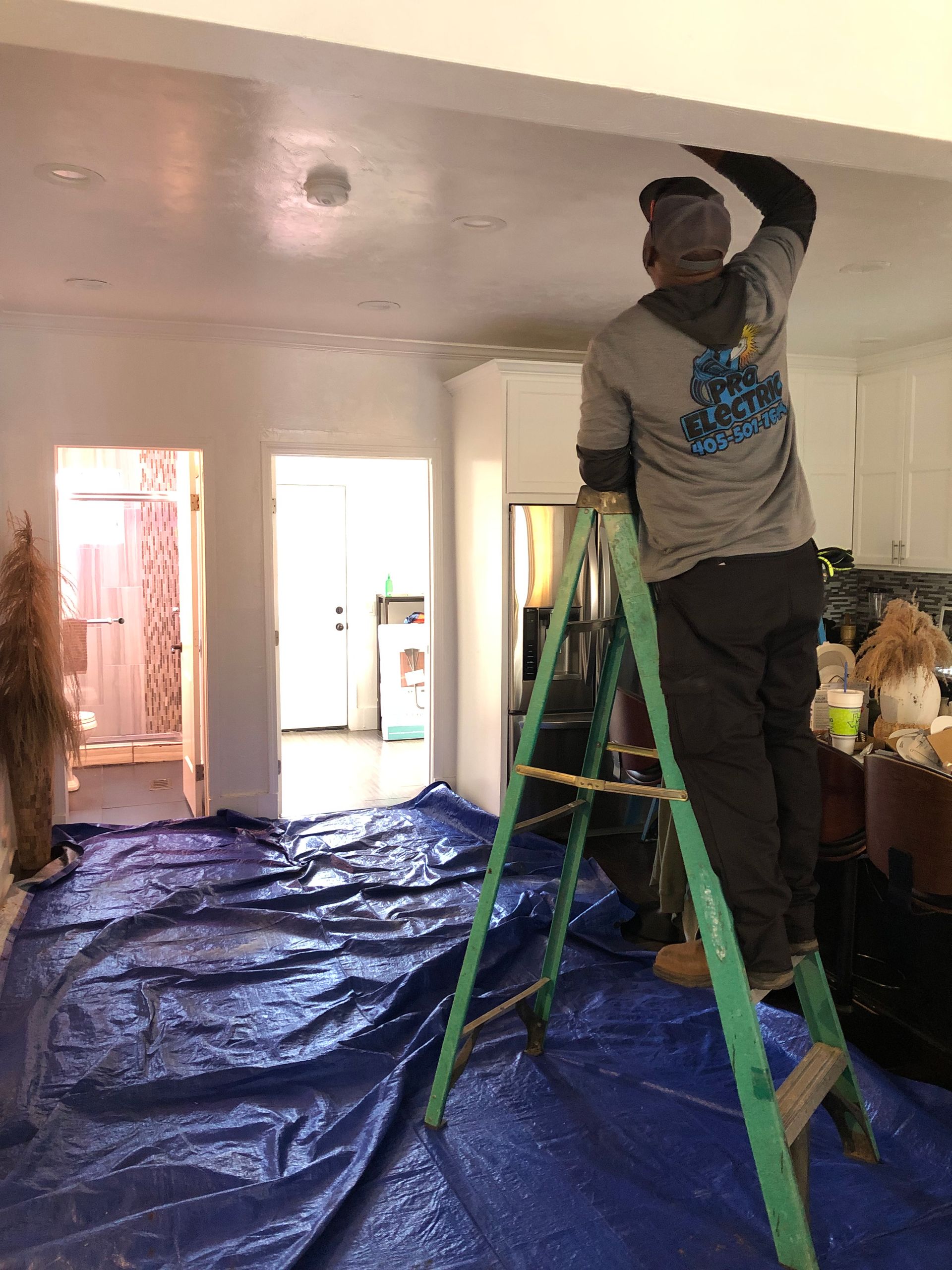 a man is standing on a ladder in a living room