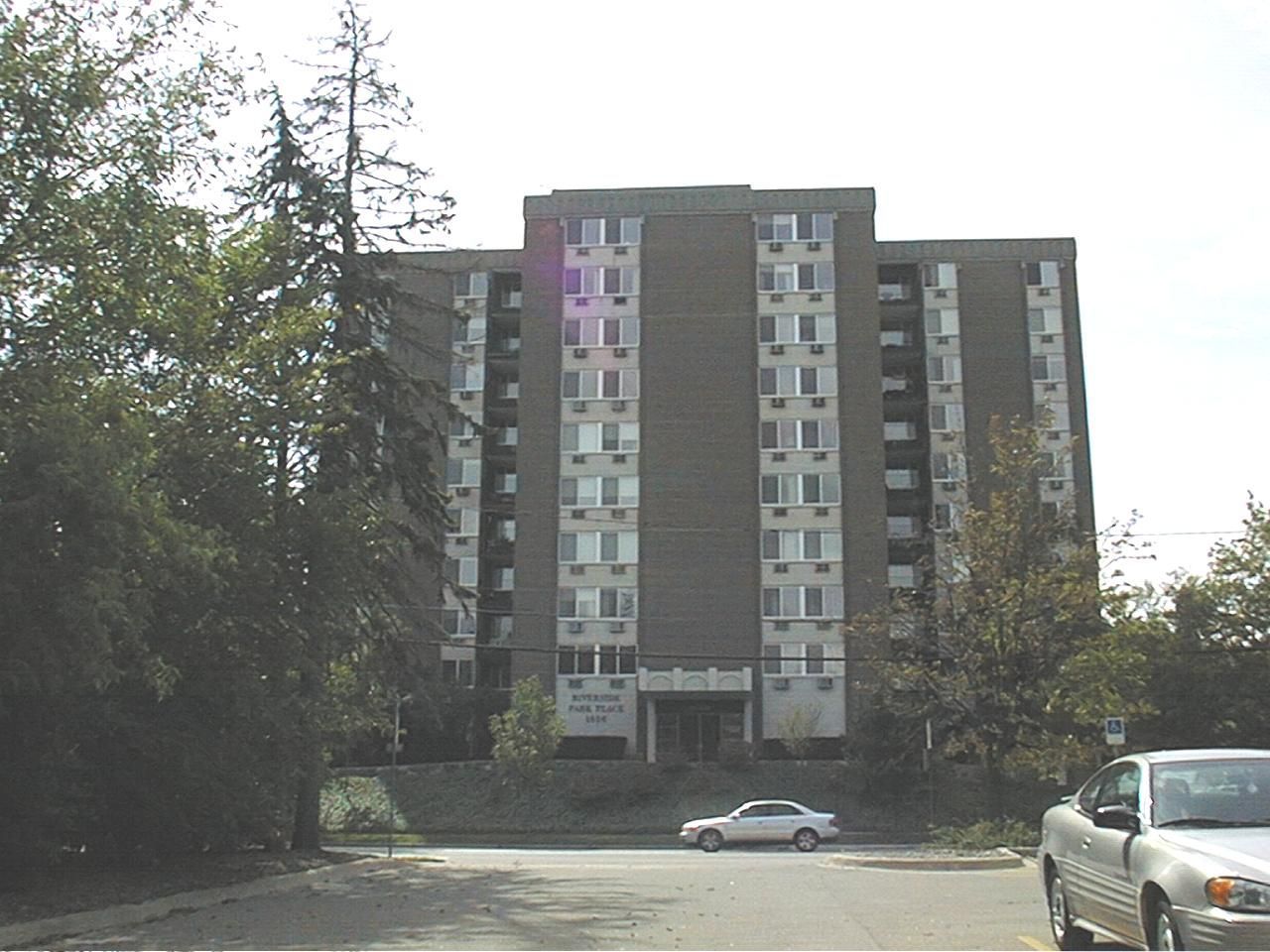A car is parked in front of a tall building