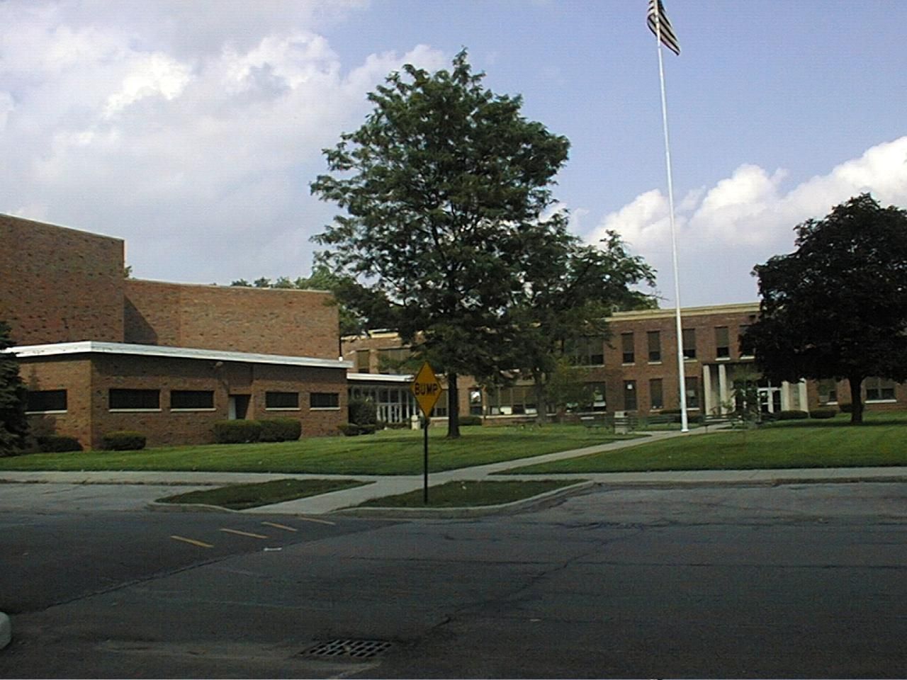 A large brick building with a flag pole in front of it