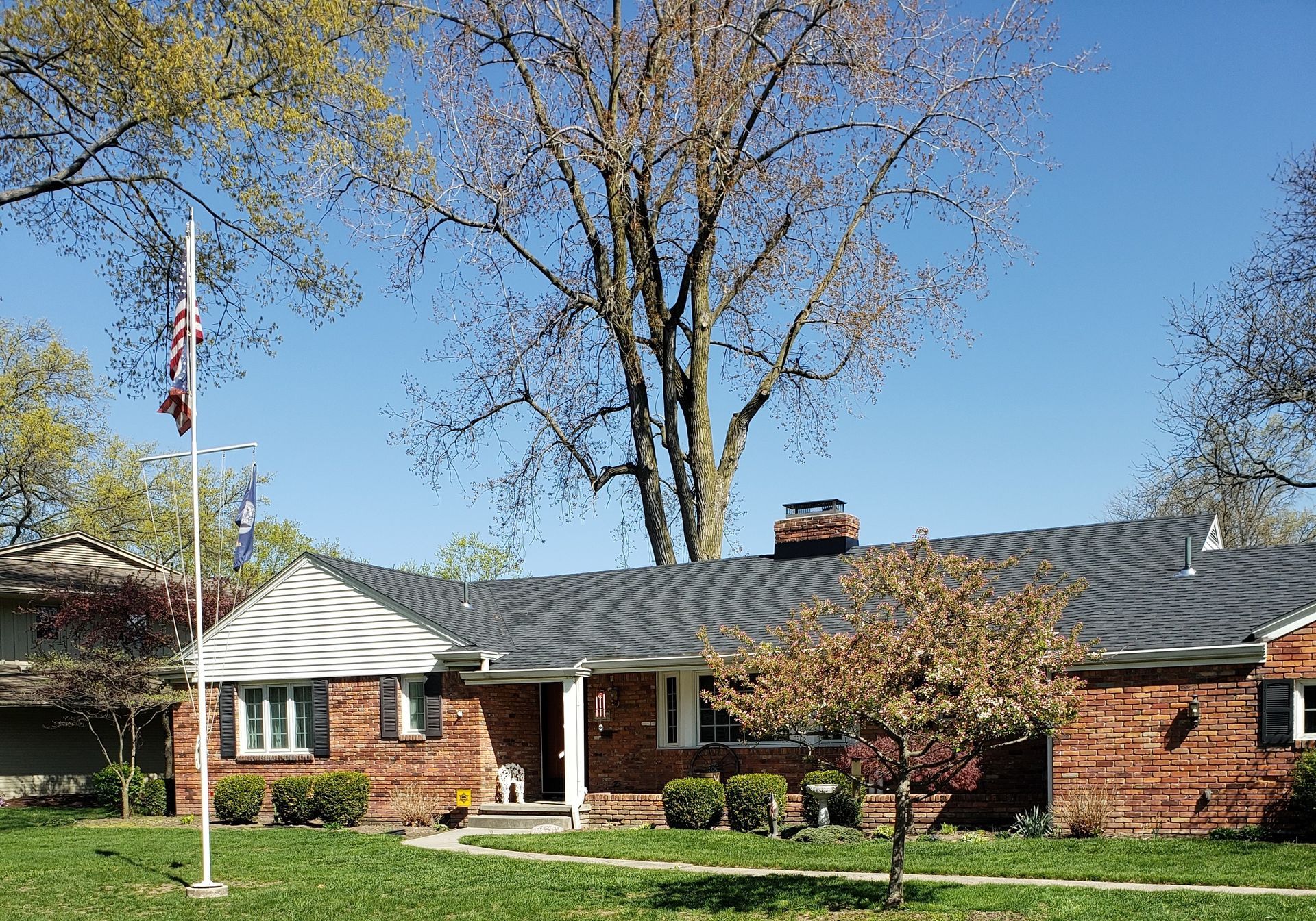 A brick house with a flag pole in front of it.