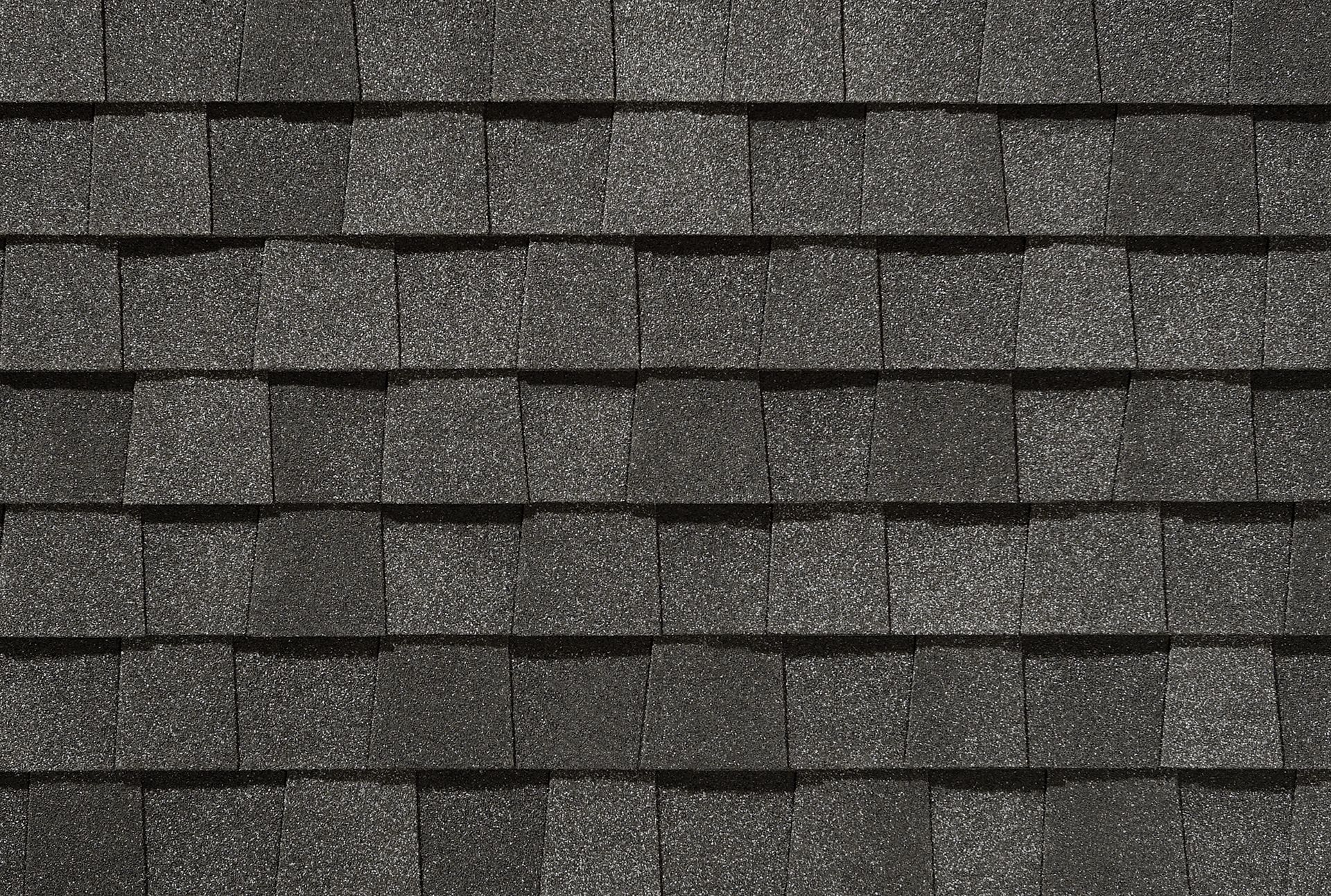 A close up of a row of black shingles on a roof.