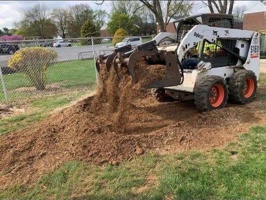 A bobcat is digging a hole in the ground.