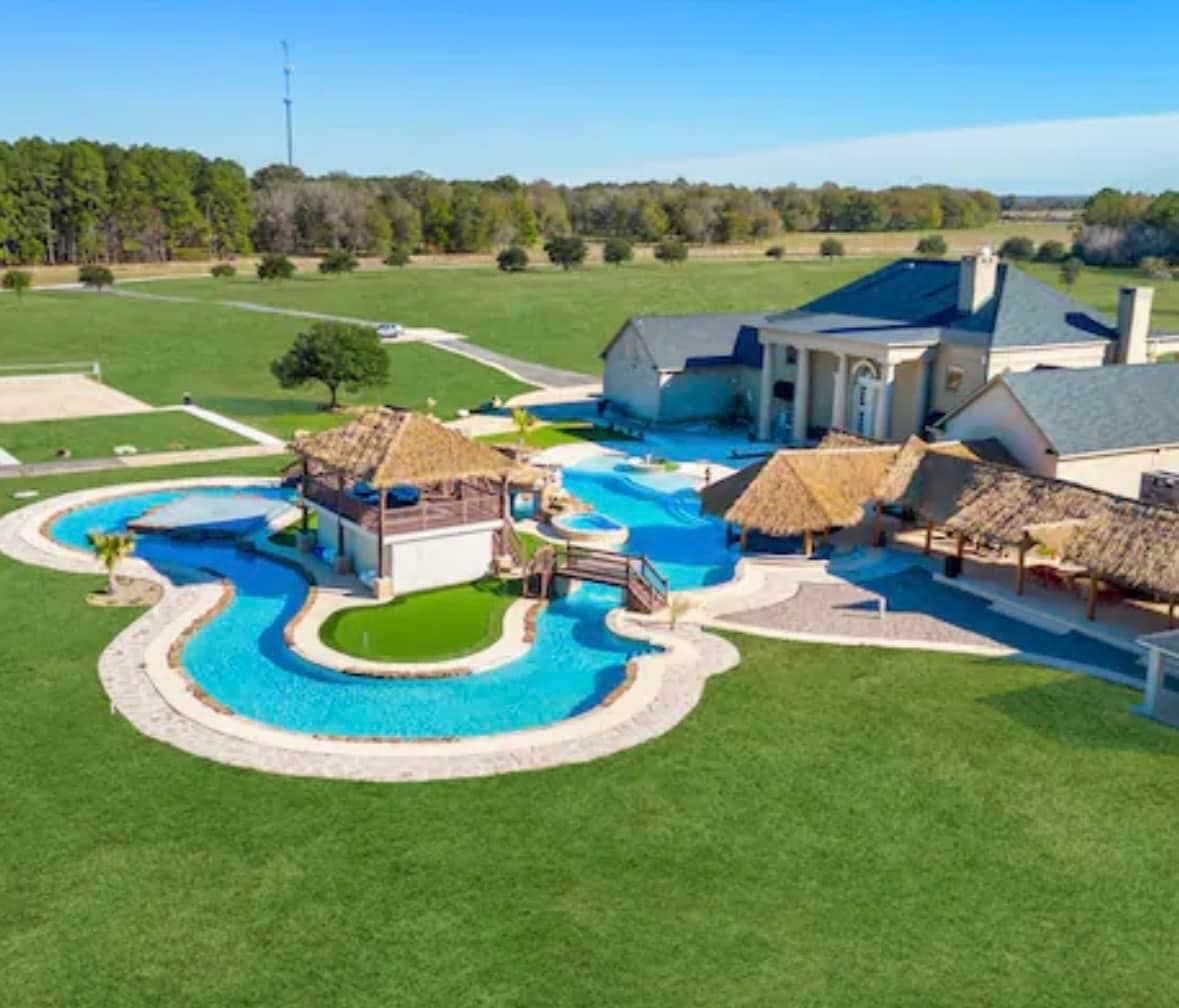 An aerial view of a large house with a swimming pool