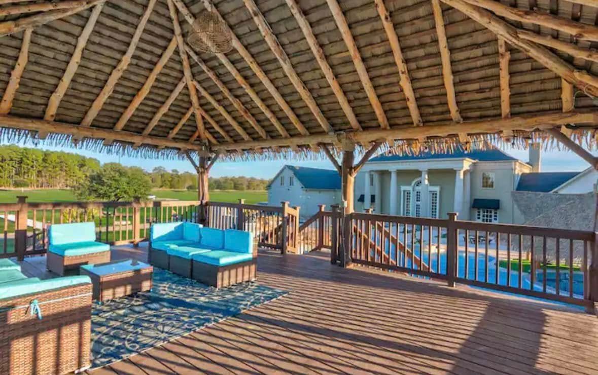 There is a gazebo with a couch and chairs underneath it.