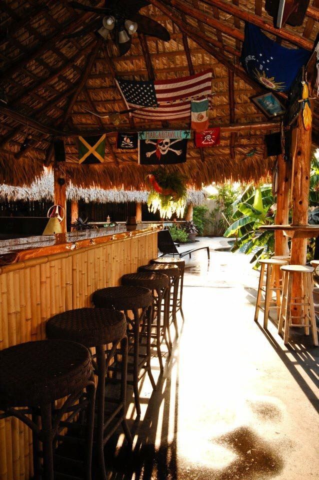 A bar with a thatched roof and flags hanging from the ceiling