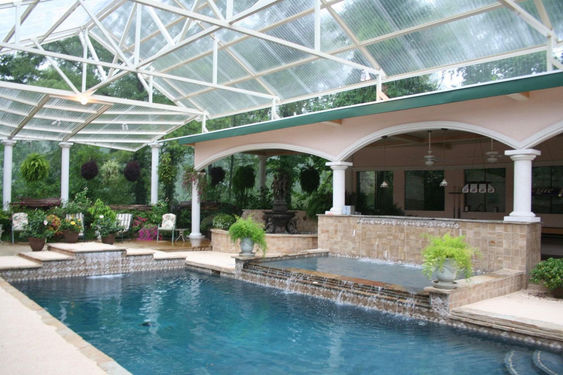 A large indoor swimming pool with a clear roof
