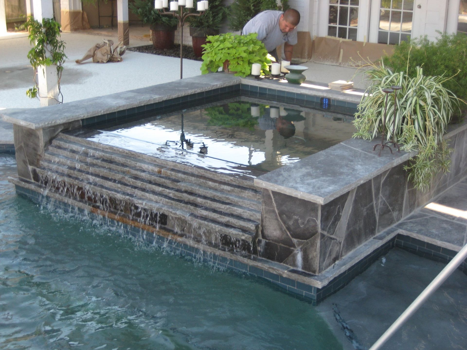 A man is working on a fountain in a pool