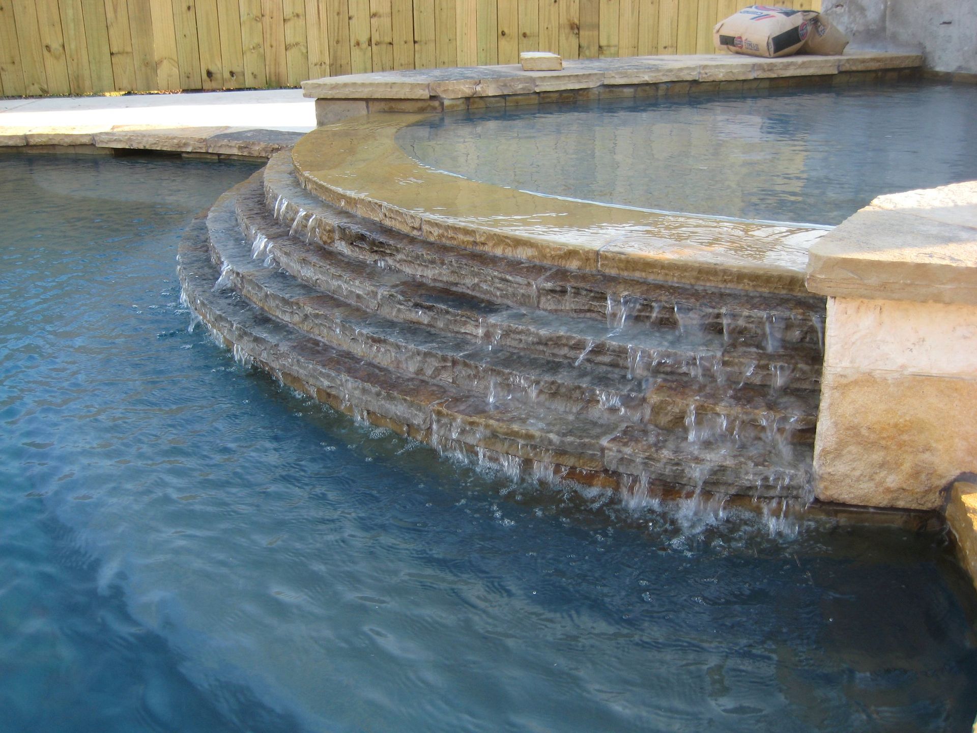 A swimming pool with a waterfall in the middle of it