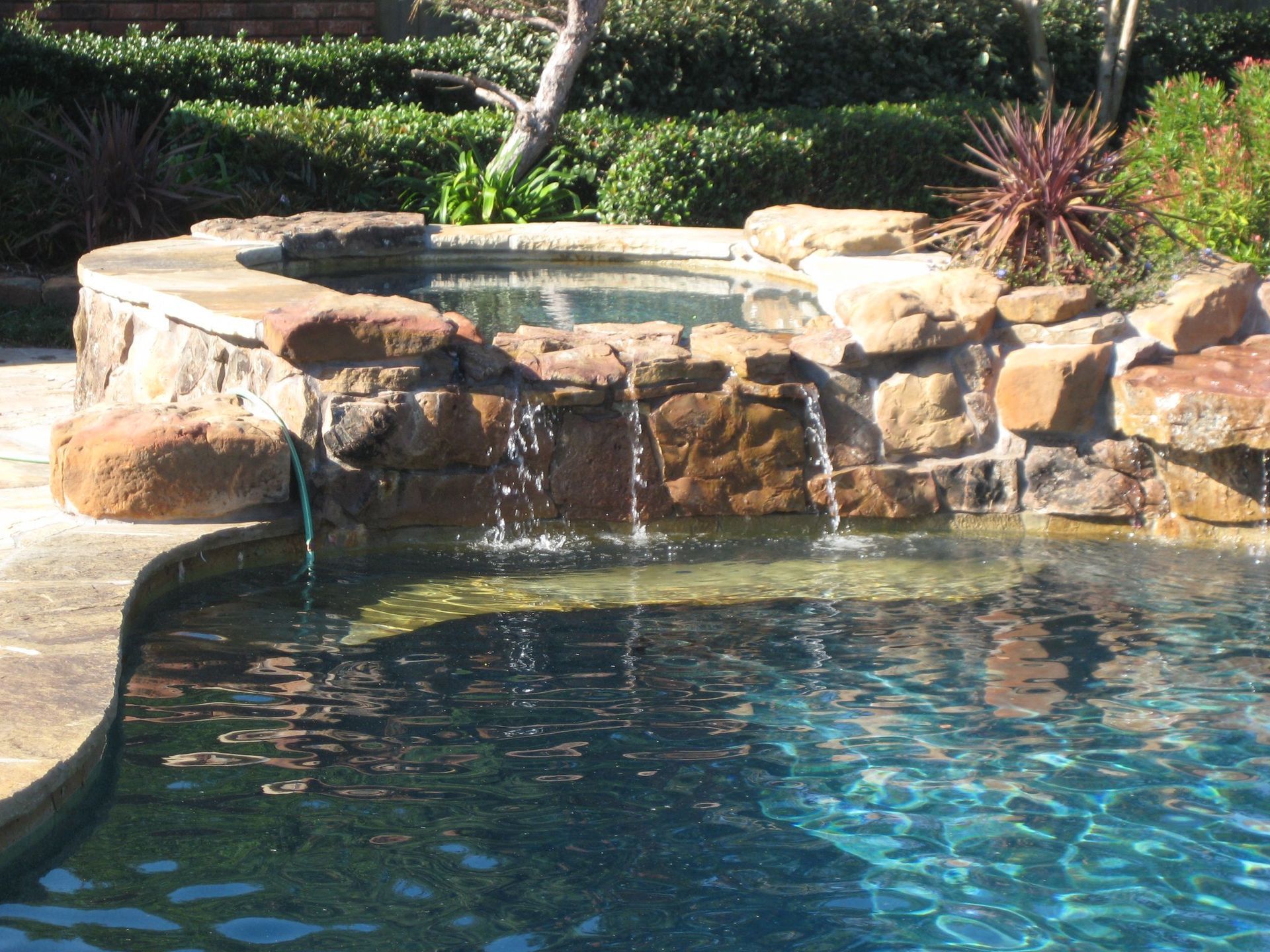 A swimming pool with a waterfall in the middle