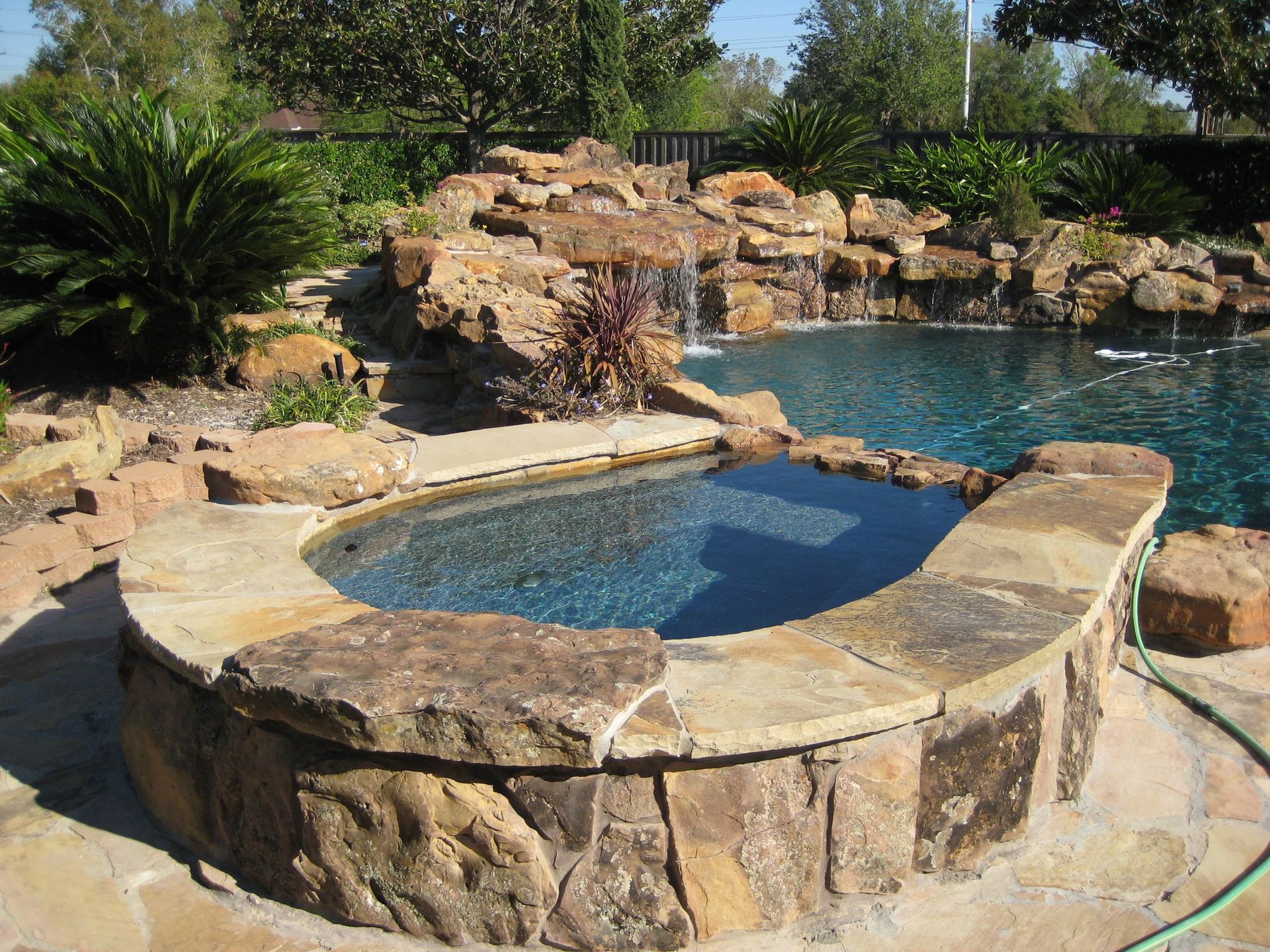 A swimming pool with a hot tub in the middle of it