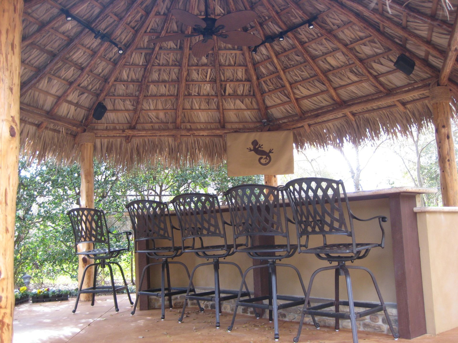 A thatched gazebo with a table and chairs underneath it