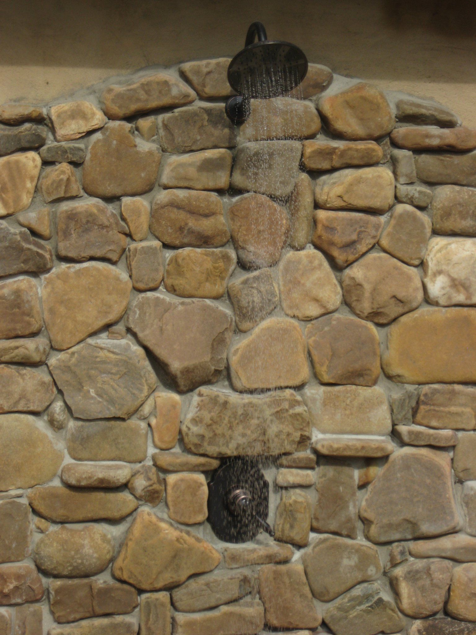 A stone wall with a shower built into it