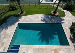 An aerial view of a large swimming pool surrounded by palm trees.