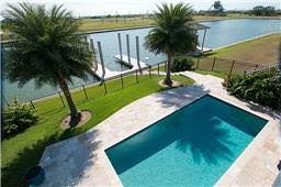 An aerial view of a large swimming pool surrounded by palm trees.