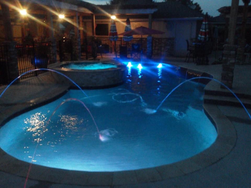 A large swimming pool is lit up at night