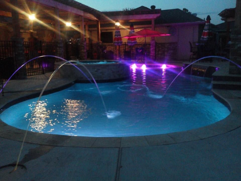 A large swimming pool is lit up at night