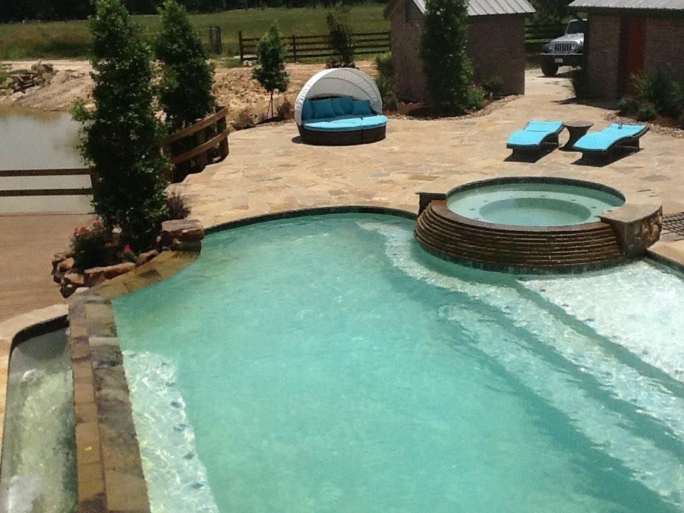A large swimming pool with a hot tub in the middle