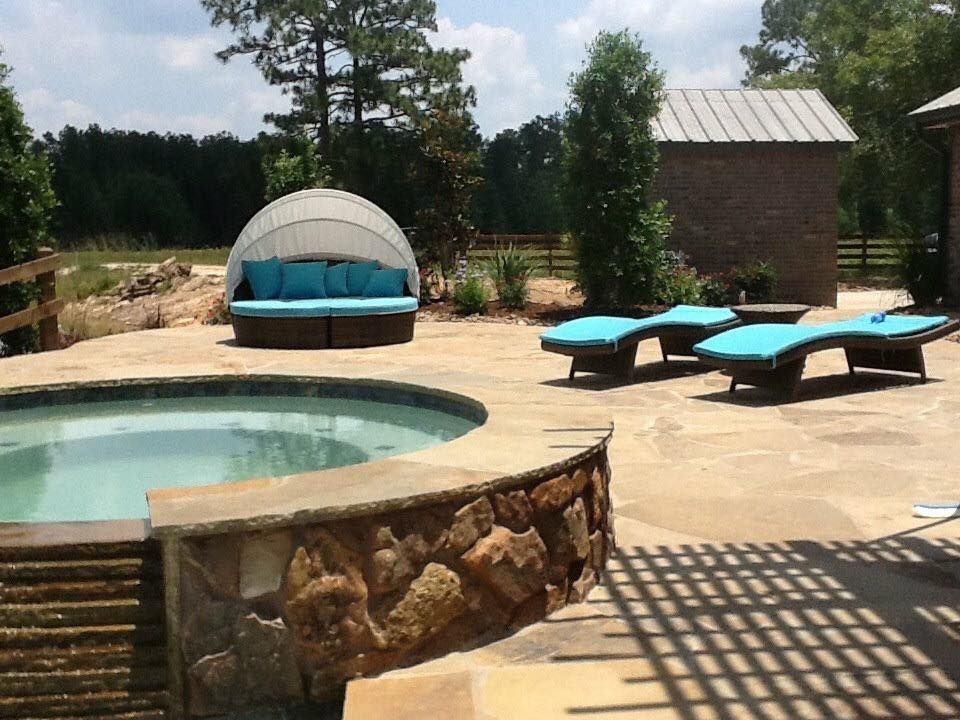 A swimming pool with a couch and chairs around it
