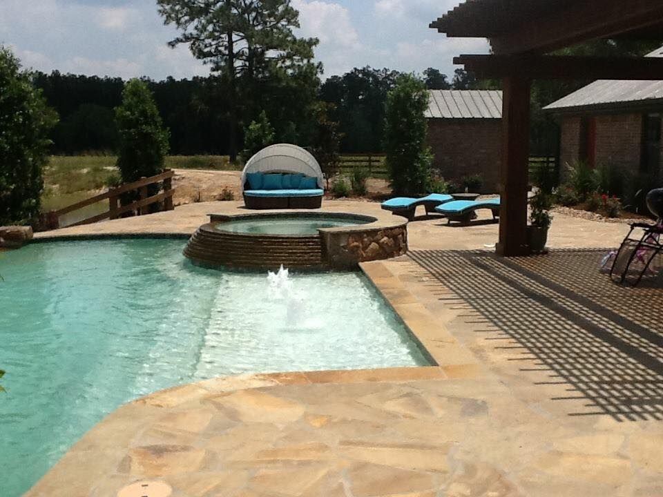 A large swimming pool with a fountain in the middle