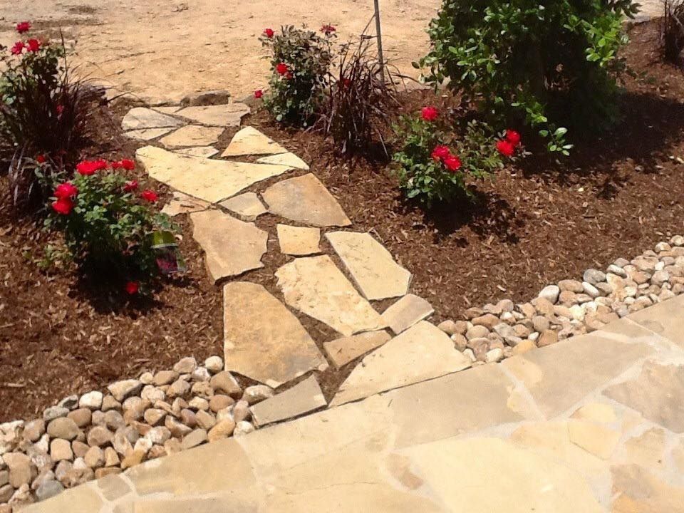 A stone walkway surrounded by rocks and flowers