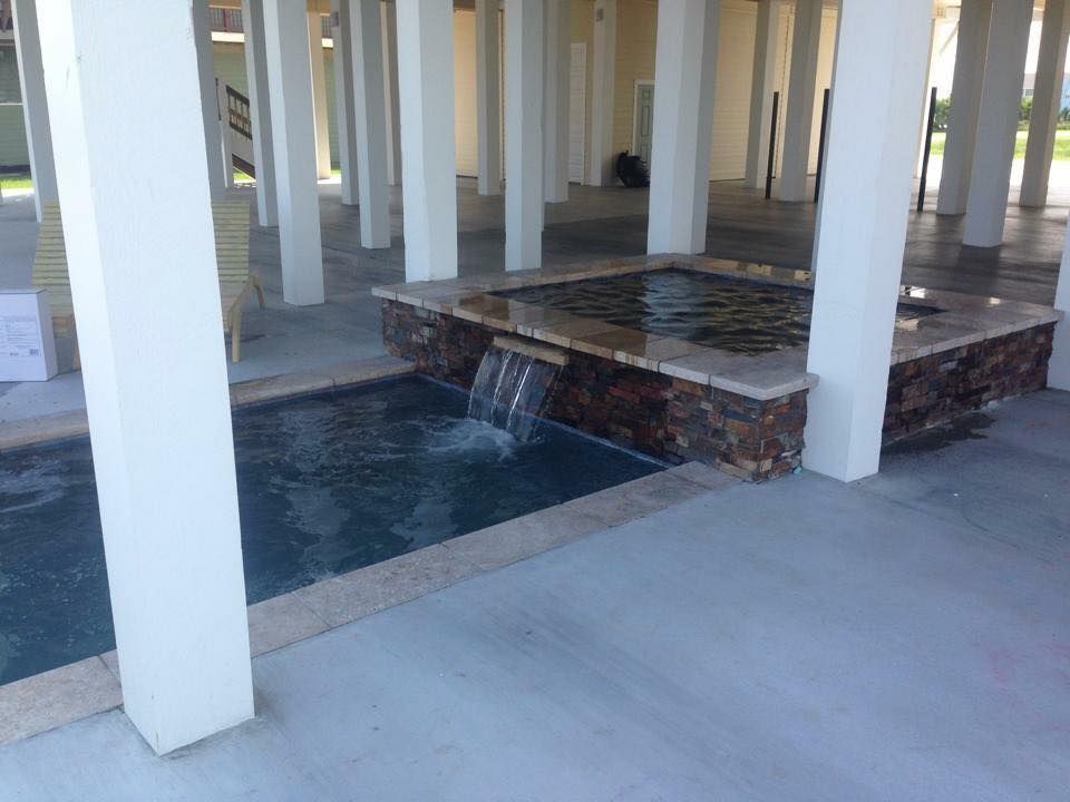 There is a waterfall in the middle of the pool.