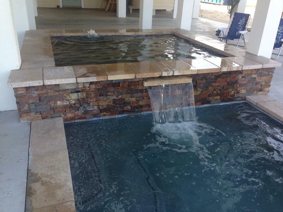 A pool with a waterfall in the middle of it