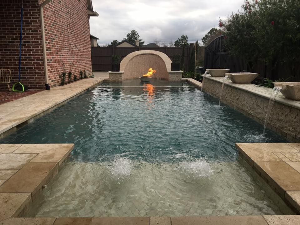 A large swimming pool with a fire feature in the middle