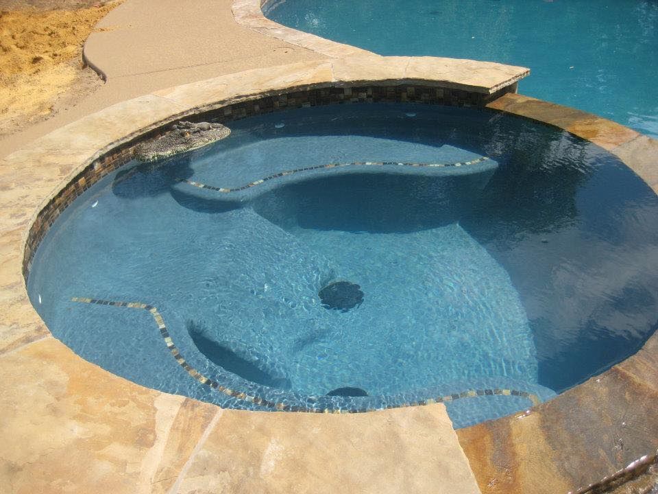 A pool with a hot tub in the middle of it