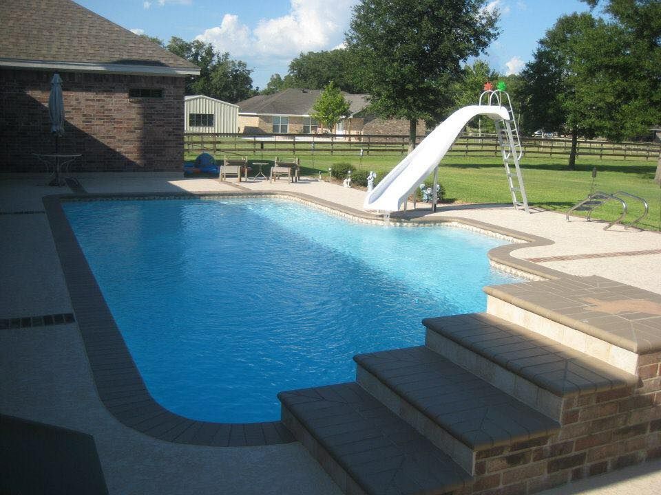 A large swimming pool with a slide attached to it