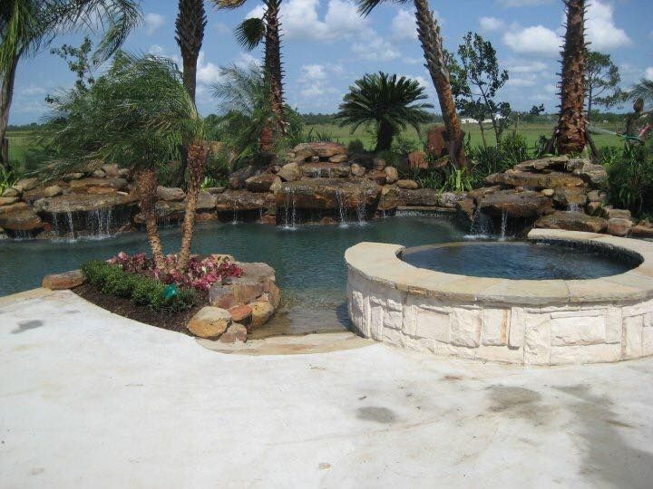 A swimming pool with a waterfall and a hot tub